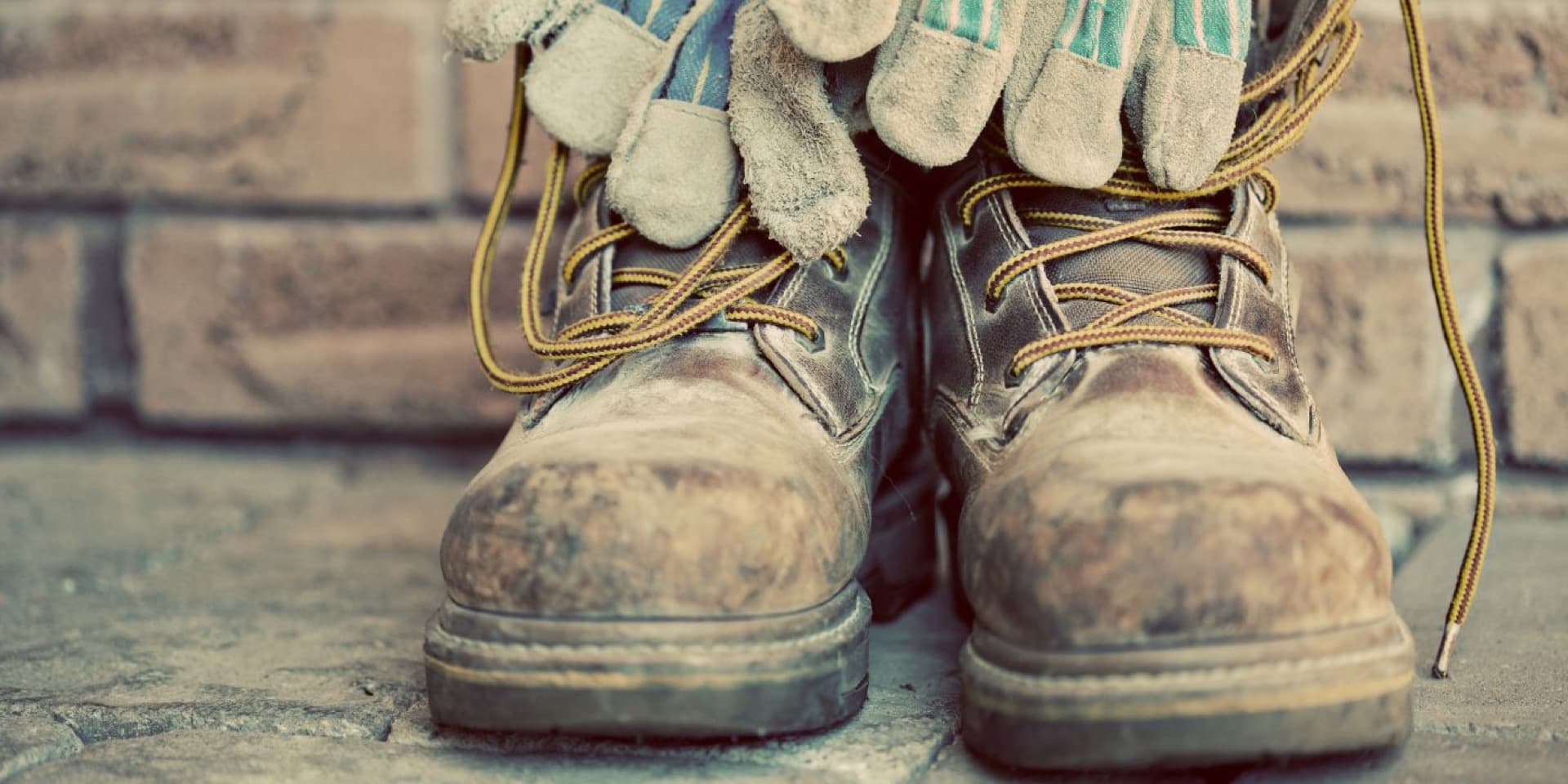 Bottes de travail à embout d'acier usées avec gants en cuir — service de réparation de bottes industrielles au Canada