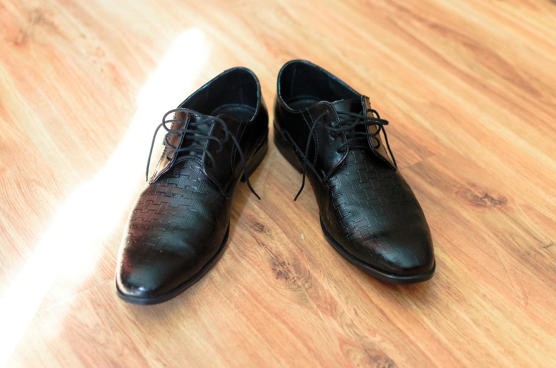 Chaussures habillées élégantes en cuir noir sur plancher de bois pour environnement professionnel corporatif