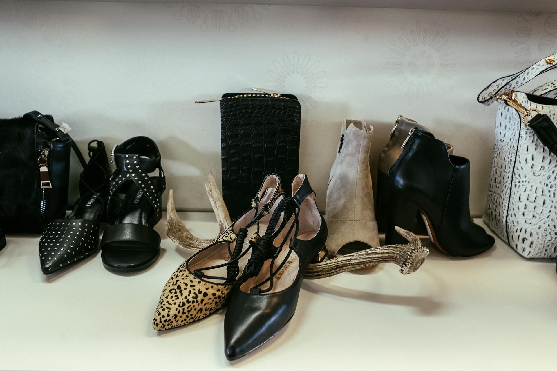 Chaussures et sacs à main de designer de luxe exposés sur des étagères dans une boutique haut de gamme