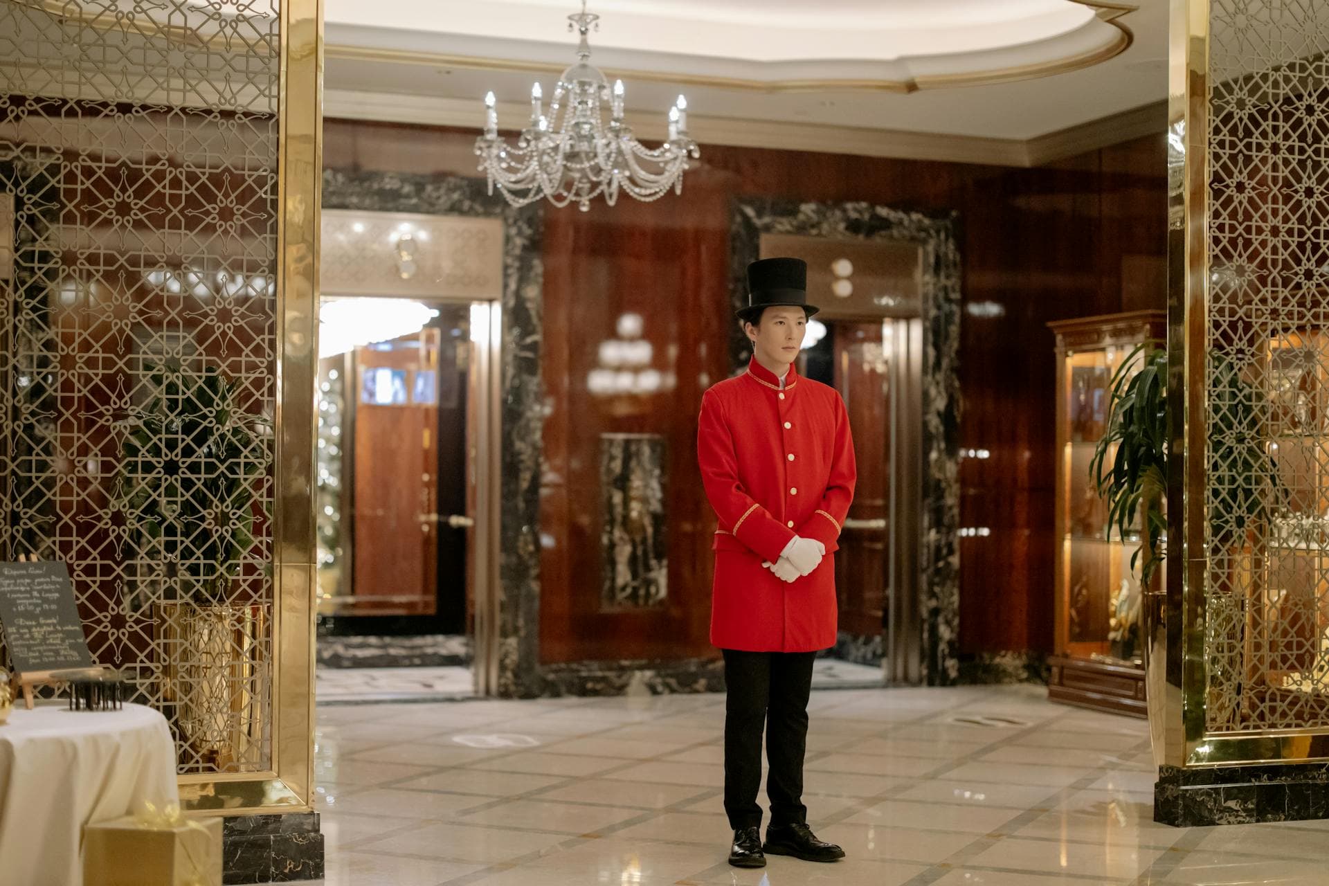 Hall d'hôtel de luxe avec concierge en uniforme dans un décor élégant de marbre et lustres