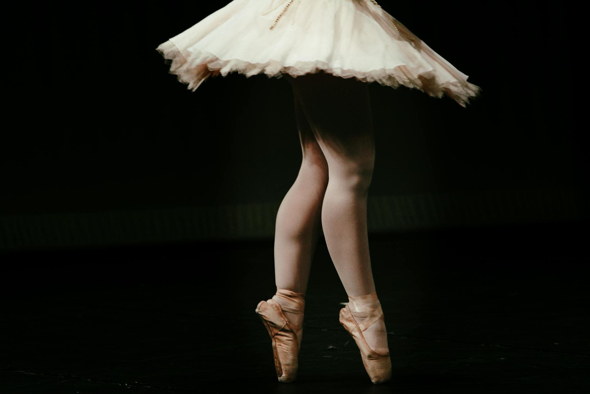 Ballerine sur pointes exécutant une performance sur scène dans un décor de ballet classique