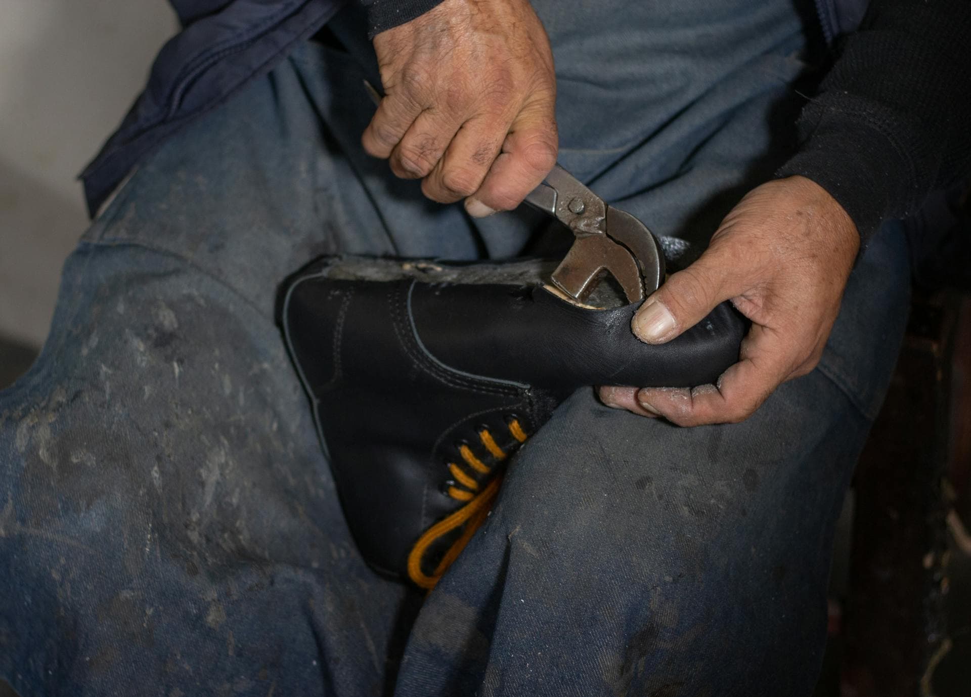Cordonnier qualifié utilisant des pinces de montage pour façonner et réparer une chaussure en cuir
